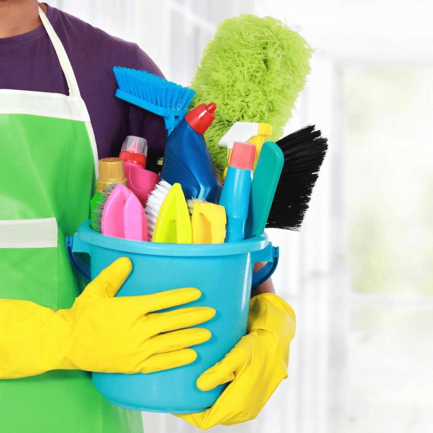 A person holding a bucket of cleaning supplies.